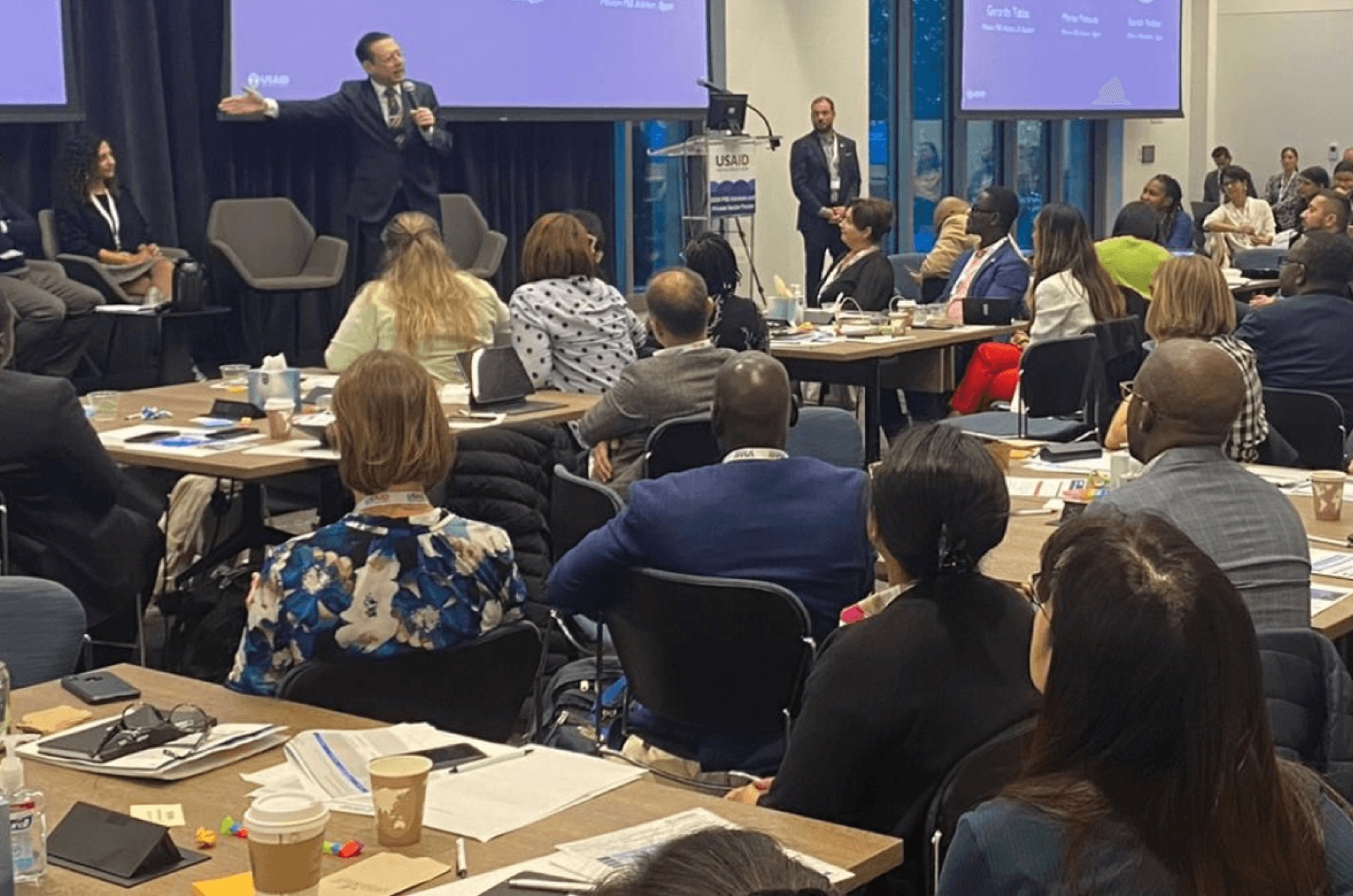 Gerardo Tablas addressing a large workshop audience with a microphone